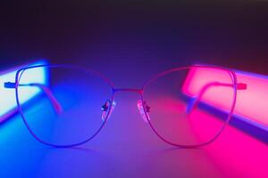 Stylish glasses shot using pink and blue abstract colored lighting with copy space. photo