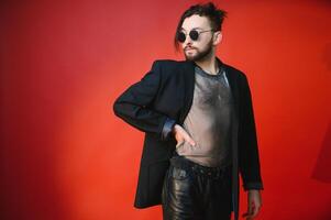 Young gay man is standing in the studio and posing for a camera. photo