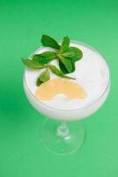 Pina Colada in front of green background. photo