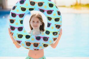 The concept of recreation at sea. The girl holds an inflatable circle for swimming by the pool photo