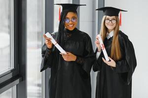 portrait of multiracial graduates holding diploma photo