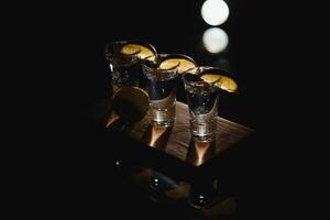 tequila con Lima en un oscuro antecedentes foto
