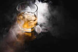 Whiskey glass black background shiny photo