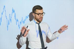 Man is standing near projector and showing graphs and business graphs. photo