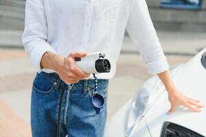 Businessman charging an electric vehicle photo