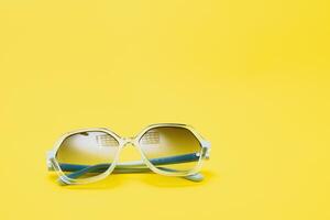 yellow sunglasses on yellow background photo