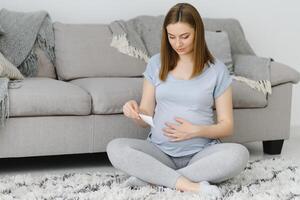 Pregnant woman looking at her baby sonography. Happy expectant lady enjoying first photo of her unborn child, anticipating her future life, copy space