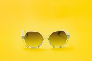 yellow sunglasses on yellow background photo