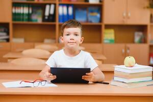 school boy using tablet compute in classroom photo