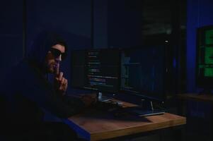 Wanted hackers coding virus ransomware using laptops and computers. Cyber attack, system breaking and malware concept photo