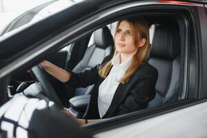 Pretty young woman driving her new car photo