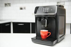 blurred background of kitchen and coffee machine with red cup and space for you photo