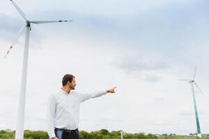 Engineer inspecting Project Manager at the Wind Farm. Man working in the enviromental photo