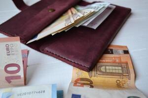 euro dinero billetes y billetera en el blanco de madera escritorio. negocio dinero antecedentes. foto