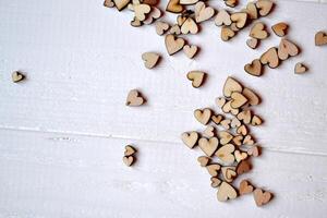 Decorative wooden hearts on a white desk. Love background. photo