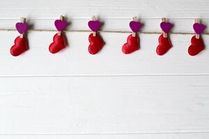 Red love hearts fastened on a decorative clothespin. photo