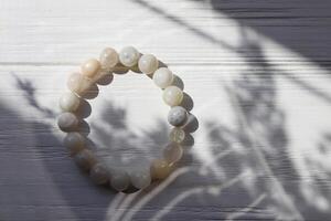 Bracelet from moonstone on a white table. photo