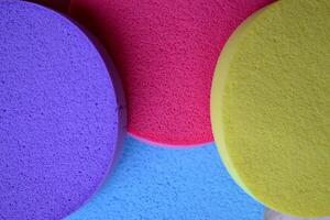 Colorful sponges on textured desk. Bright abstract background. photo