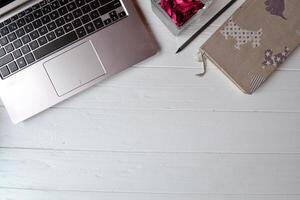 Laptop, notebook, pencil and decor on the white wooden desk. Business flat lay. photo