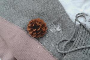 Winter woolen textile. Scarf and mittens on the snow. Beautiful winter background. Cold season. photo