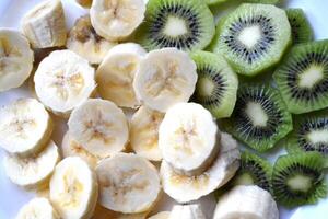 Fruits background. Banana and kiwi on the white background photo