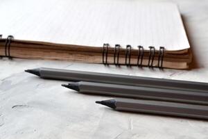 Grey pencils and notepad on the desk. Tools for sketching. photo