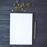 White paper and pencil with decoration on the wooden desk, top view. photo