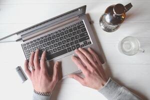 Man working at a laptop, additional business form background, mobile phone laptop operation business photo