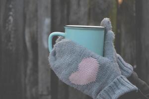 A mug of tea in cold weather. A cup of tea in woman's hands. photo