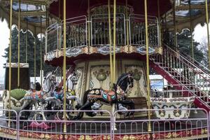 Vintage european carousel in a park. Merry go round horses. Retro style carousel. photo