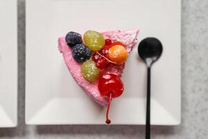 The piece of fruit cake with berries on a white plate. photo