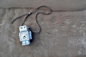 Bag in the form of a robot on the sand. photo