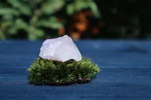 Rose quartz and moss on a blue wooden table. photo