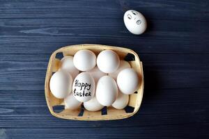 Eggs in a basket on the wooden vintage table. Happy Easter Day. Easter backgrund. photo