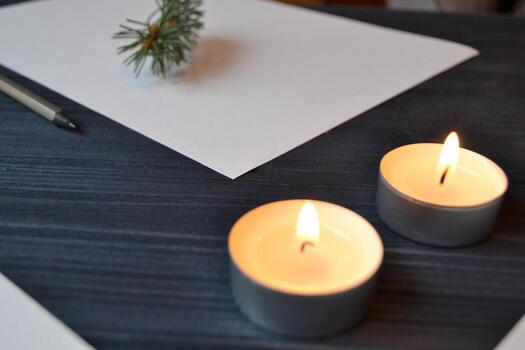 White paper and lighted candles on the table. Minimalism. Stylish background. photo