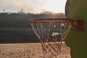 baloncesto en el puesta de sol playa. baloncesto anillo en el playa. foto