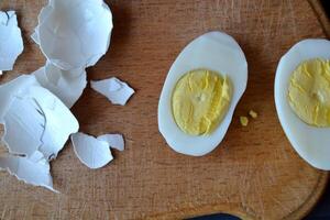 Sliced eggs, eggs shell on a wooden board. Macro food photography. Homemade food still life. photo