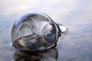 Light bulb in the water. Electricity lamp. photo