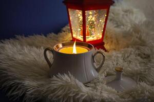 ardiente vela y rojo linterna en el blanco tartán. Navidad decoraciones foto