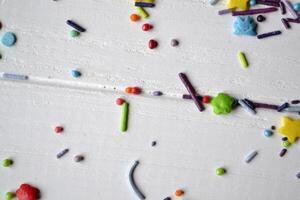 Colorful sugar on the table. Bright sweet powder for cake on the white wooden background. Beautiful abstract background. photo