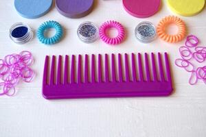 Colorful and bright cosmetics. Beauty care tools. Beauty salon. Girl's paradise. Nail polishes, sequins, pink hair bands and comb on the white wooden desk. Bright still life of beauty instruments. photo
