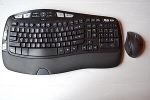 Black keyboard and mouse on the white table. photo