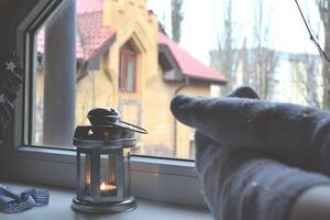 Legs in socks. Woman relaxing at home near the window. Decor in the living room. photo