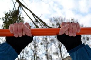 Male hands on the holizontal bar. Man is engaged in sports. photo