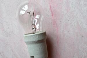 Electricity light bulb on the grey textured background. photo