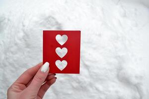 Red love card in female hand. photo