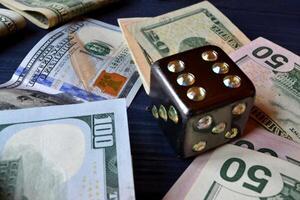 Dice cube with precious jewels on the table and money. Plaing cube. Games of chance. photo