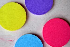 Colorful sponges on textured desk. Bright abstract background. photo
