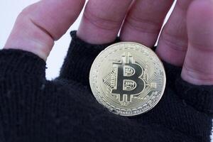 Golden bitcoin in male hand. Gold coin of cryptocurrency. photo