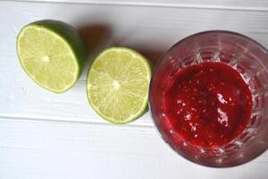 Ingredients for cooking natural tea. Mint, lime, raspberry and sea buckthorn jams on the white wooden table. photo